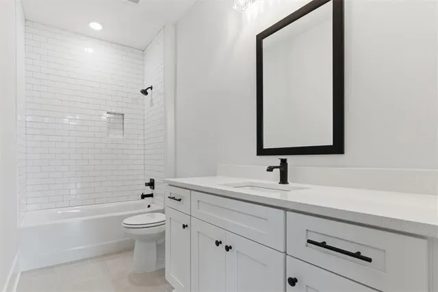 a bathroom with a toilet a sink a mirror and bathtub