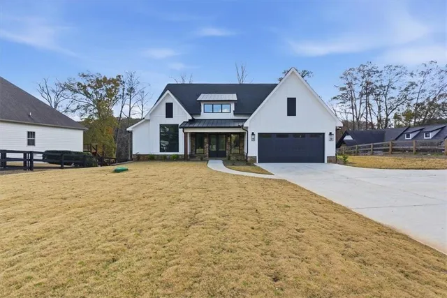 a view of a house with a yard and a large tree