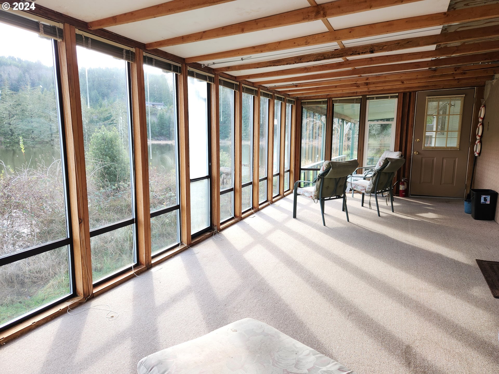 100 River Bend Road, Unit 36 Reedsport, OR 97467 - Photo 17 of 38 a view of a porch with furniture and a lot of large windows