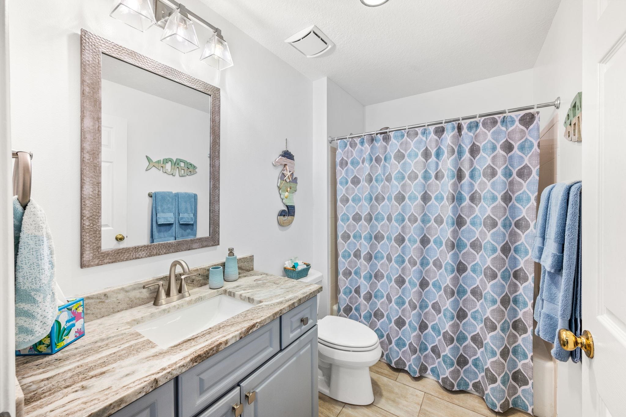 285 Atlantis Circle, Unit 203 St. Augustine, FL 32080 - Photo 42 of 71 a bathroom with a granite countertop sink a toilet and a mirror