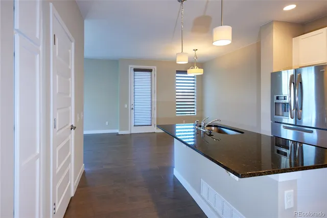a kitchen with stainless steel appliances granite countertop a refrigerator and a sink