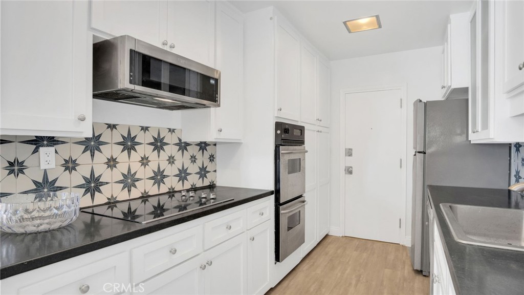 10725 Ohio Avenue, Unit 301 Los Angeles, CA 90024 - Photo 15 of 39 a kitchen with granite countertop a refrigerator stove and microwave