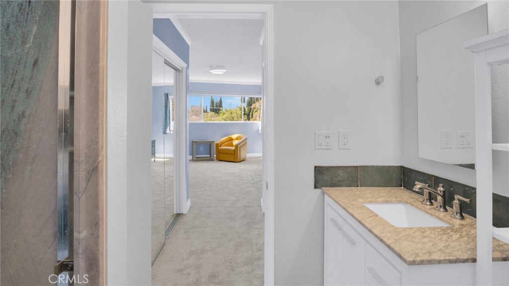 10725 Ohio Avenue, Unit 301 Los Angeles, CA 90024 - Photo 24 of 39 a bathroom with a granite countertop sink and a mirror