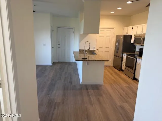 a kitchen with stainless steel appliances a refrigerator and wooden floor