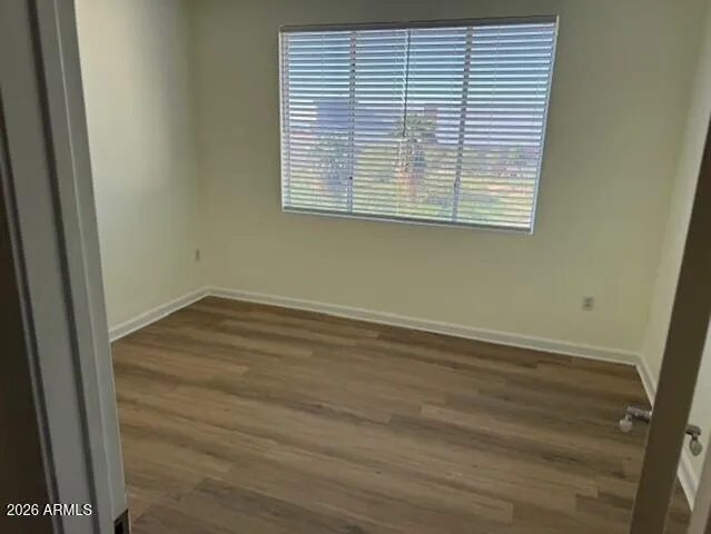 an empty room with wooden floor and a window