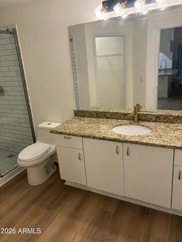a bathroom with a granite countertop sink and a mirror