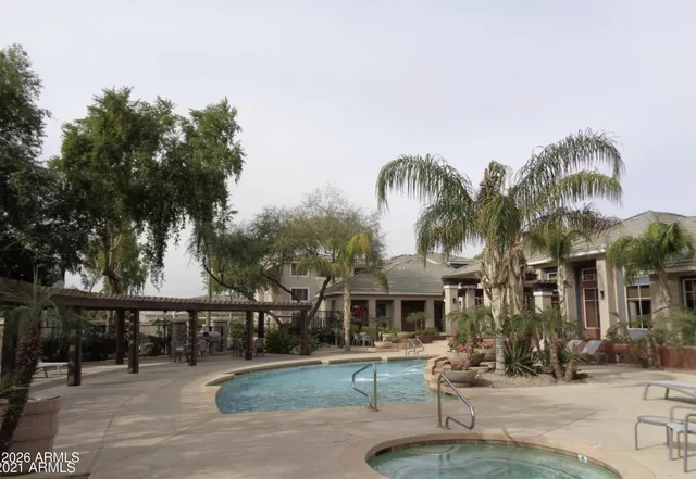 a view of a swimming pool with a patio and a yard