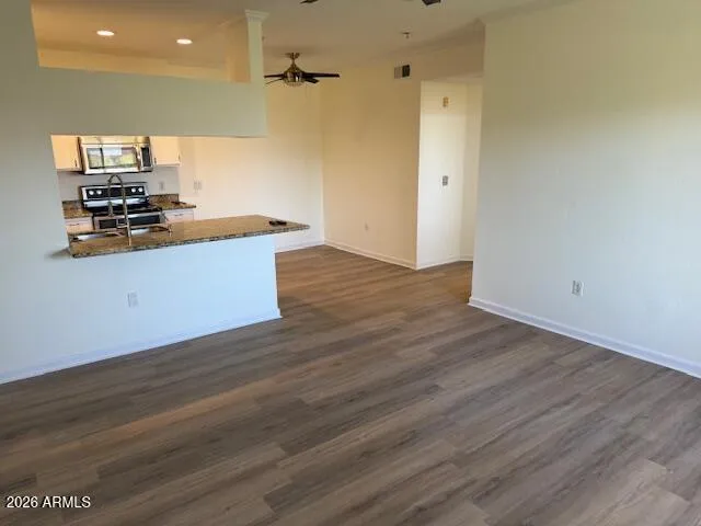 a kitchen with stainless steel appliances wooden floors and view
