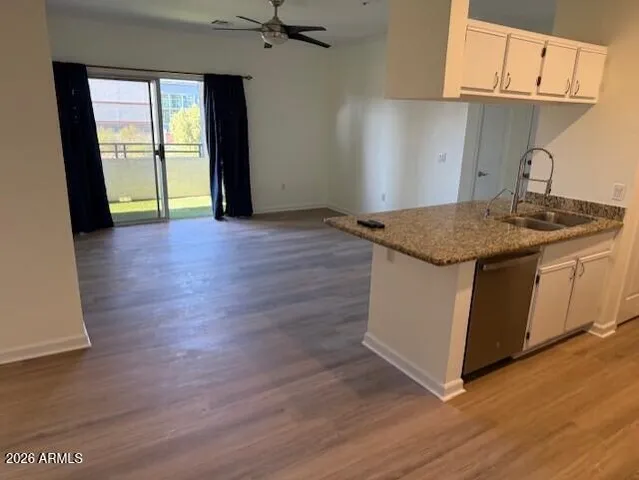 a kitchen with granite countertop wooden floors and wide window