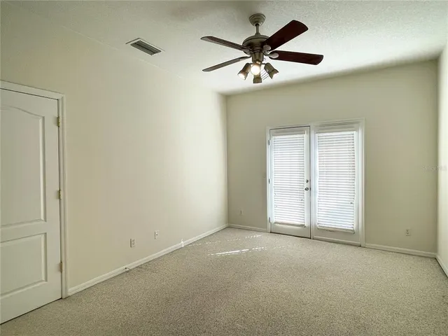 an empty room with closet and a ceiling fan