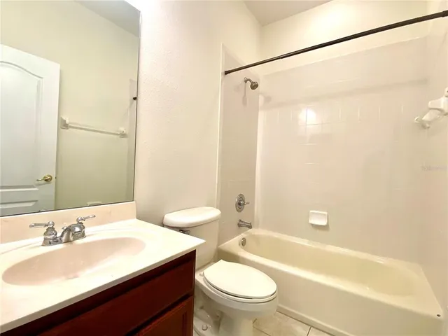 a bathroom with a sink a toilet a mirror and shower