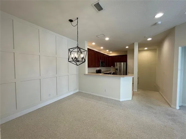 a kitchen with kitchen island a counter top space cabinets and stainless steel appliances