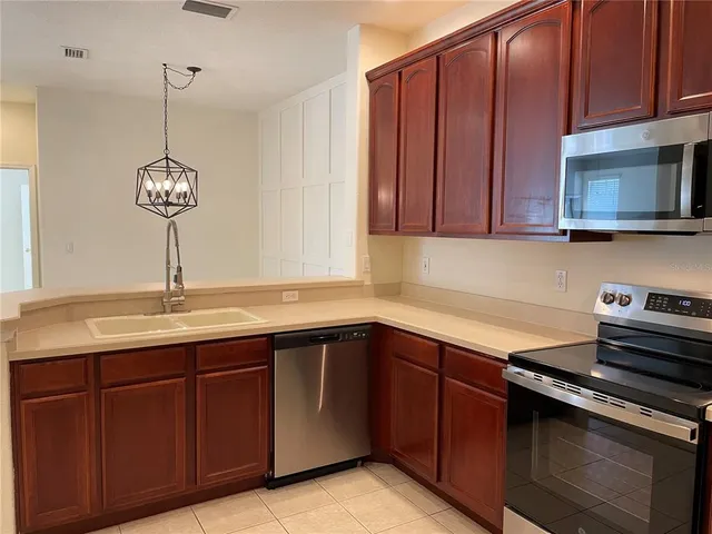 a view of a room with a hanging light and kitchen