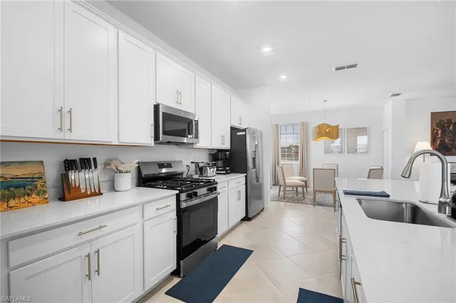 a kitchen with stainless steel appliances granite countertop a sink a stove top oven a counter space and cabinets