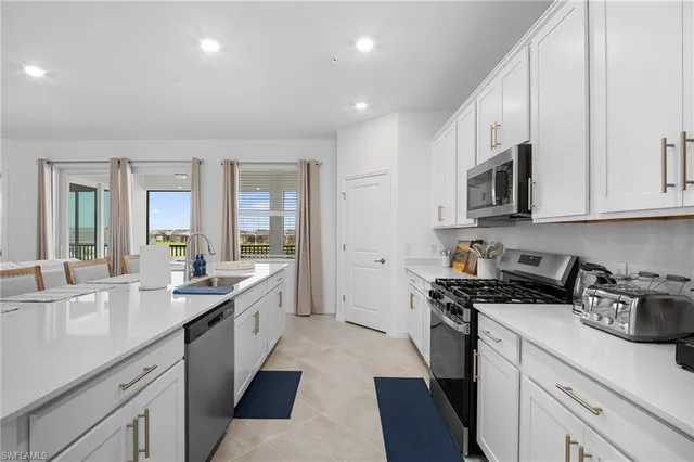 a kitchen with stainless steel appliances granite countertop a sink stove and cabinets