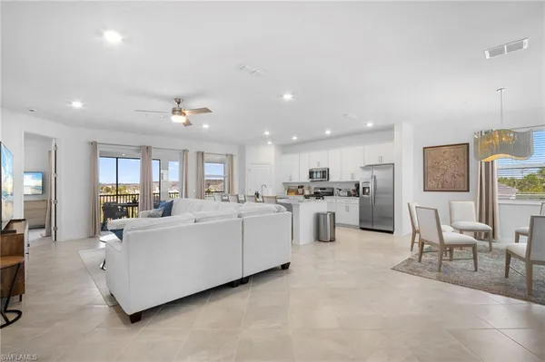 a living room with furniture and a dining table with kitchen view