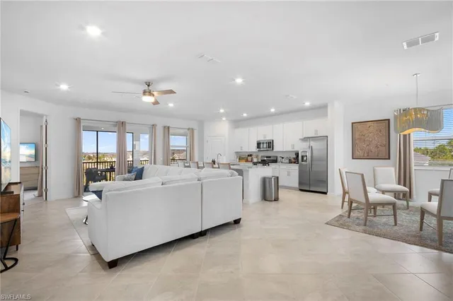 a living room with furniture and a dining table with kitchen view