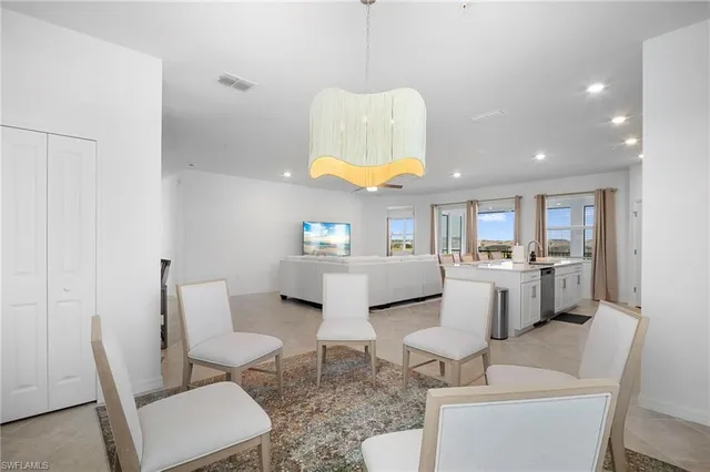 a living room with furniture a rug and kitchen view