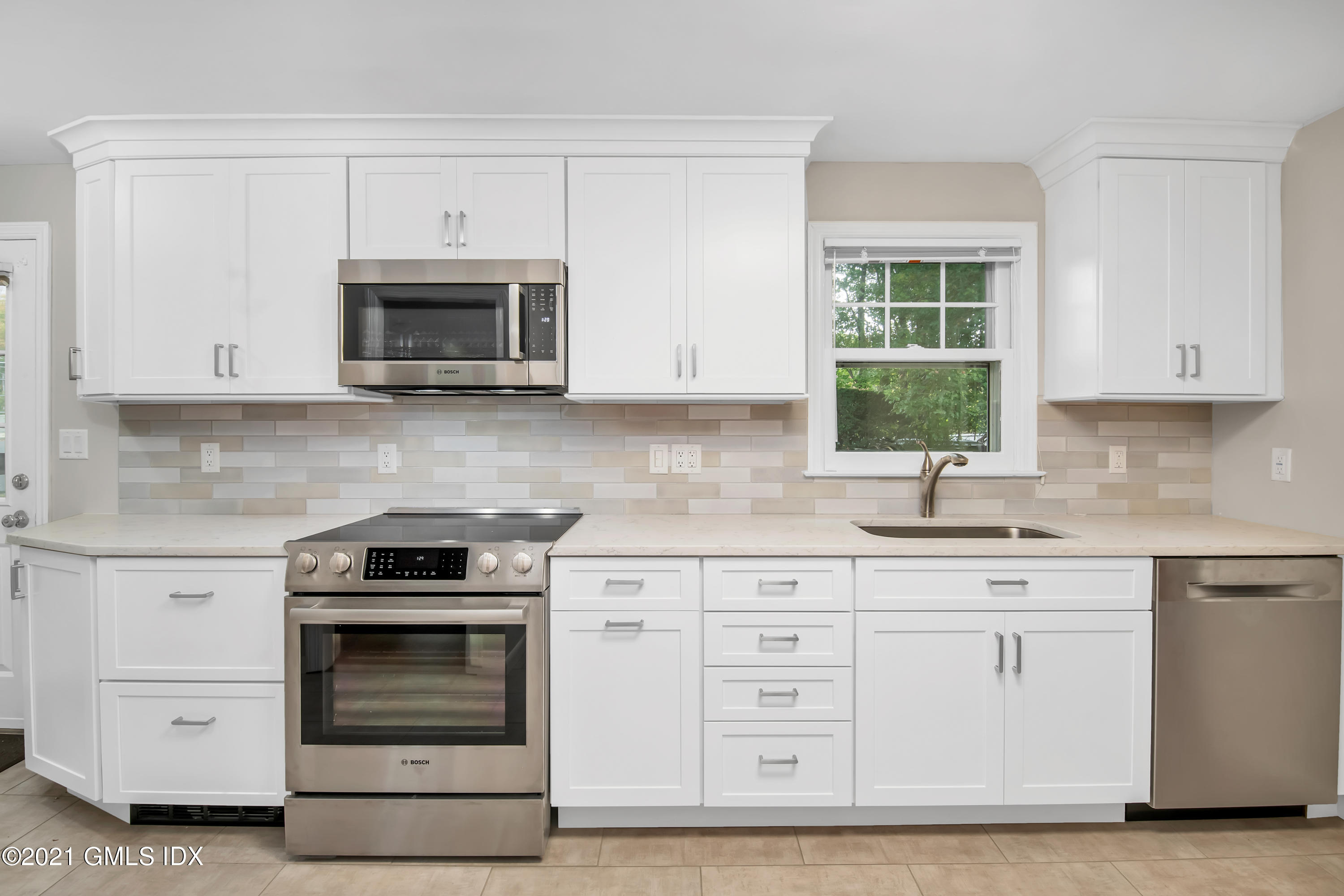 30 Pleasant Street Riverside, CT 06878 - Photo 8 of 19 a kitchen with white cabinets and stainless steel appliances