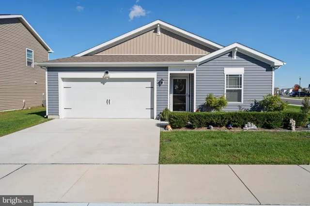 a view of a white house next to a yard