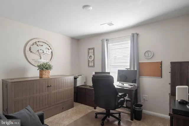 a view of a workspace with furniture and a window