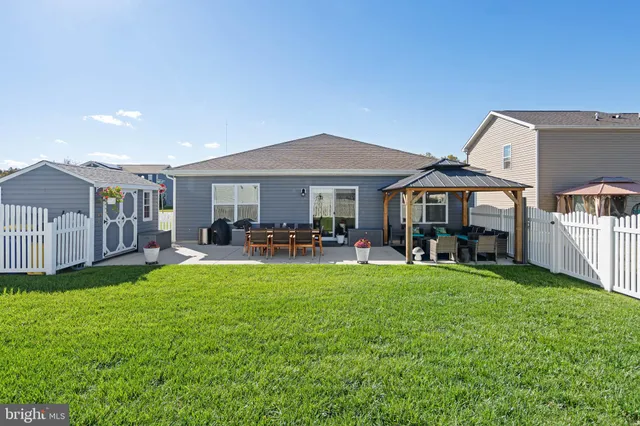 a patio with table and chairs and potted plants