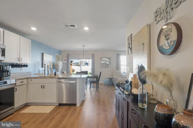 a kitchen with a dining table chairs refrigerator and cabinets
