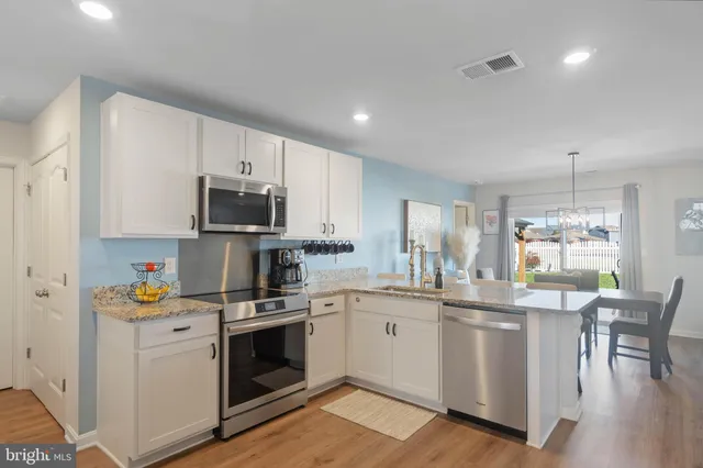 a kitchen with white cabinets stainless steel appliances and sink