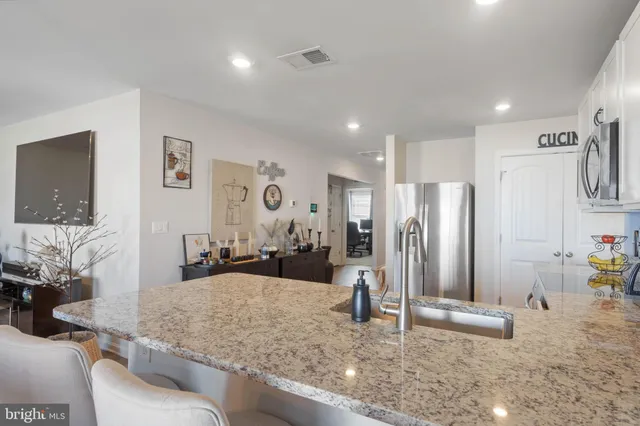 a kitchen with stainless steel appliances granite countertop a sink refrigerator and cabinets