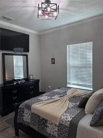 a bedroom with a bed and a chandelier