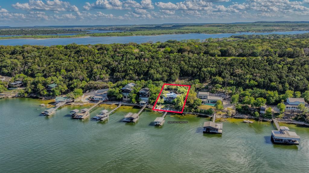 Aerial view of property and surrounding area with a nearby body of water and property parcel outlined
