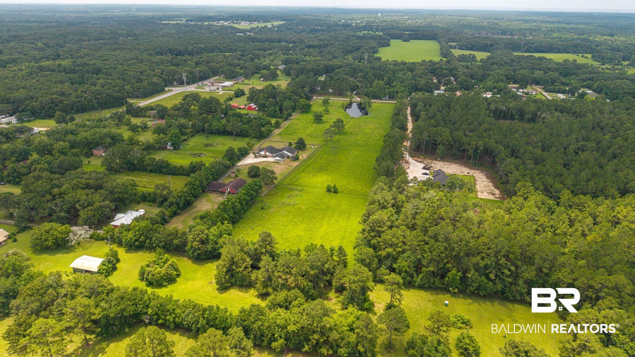 7540 2 Mile Road Irvington, AL 36544 - Photo 75 of 82 Expansive rural property featuring a large green field, mature tree lines, and a visible pond