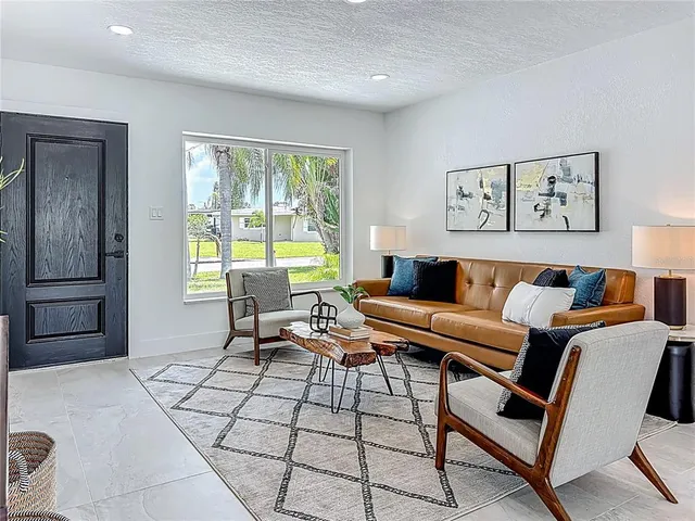 a kitchen with stainless steel appliances granite countertop white cabinets a sink a stove a microwave and island