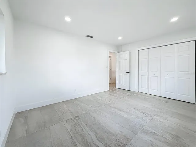 a bedroom with a bed and a potted plant