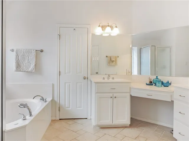 a spacious bathroom with a double vanity sink a mirror a bathtub and