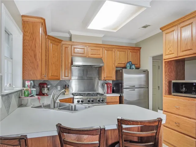 a kitchen with a refrigerator a stove a sink dishwasher and cabinets