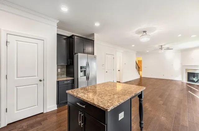 a kitchen with stainless steel appliances granite countertop a kitchen island a refrigerator and a sink