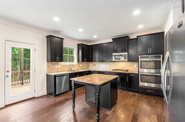 a kitchen with stainless steel appliances granite countertop a sink stove and refrigerator