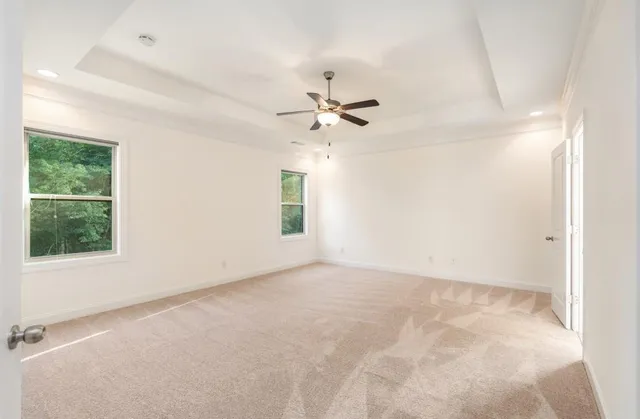 an empty room with a window and a ceiling fan