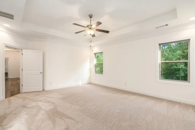 an empty room with windows and fan