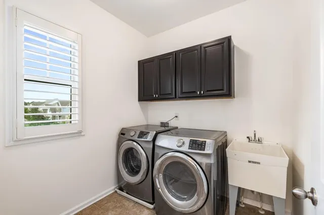 a utility room with sink dryer and washer