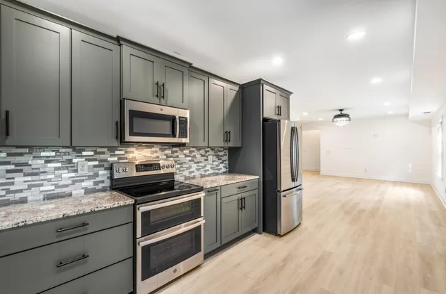 a kitchen with stainless steel appliances granite countertop a refrigerator and a stove top oven
