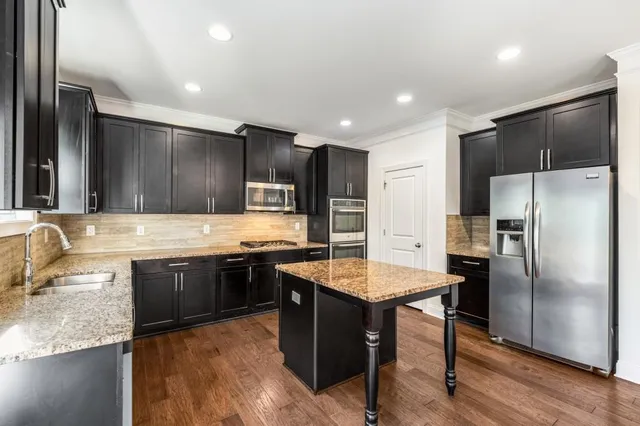 a kitchen with stainless steel appliances granite countertop a sink stove and refrigerator