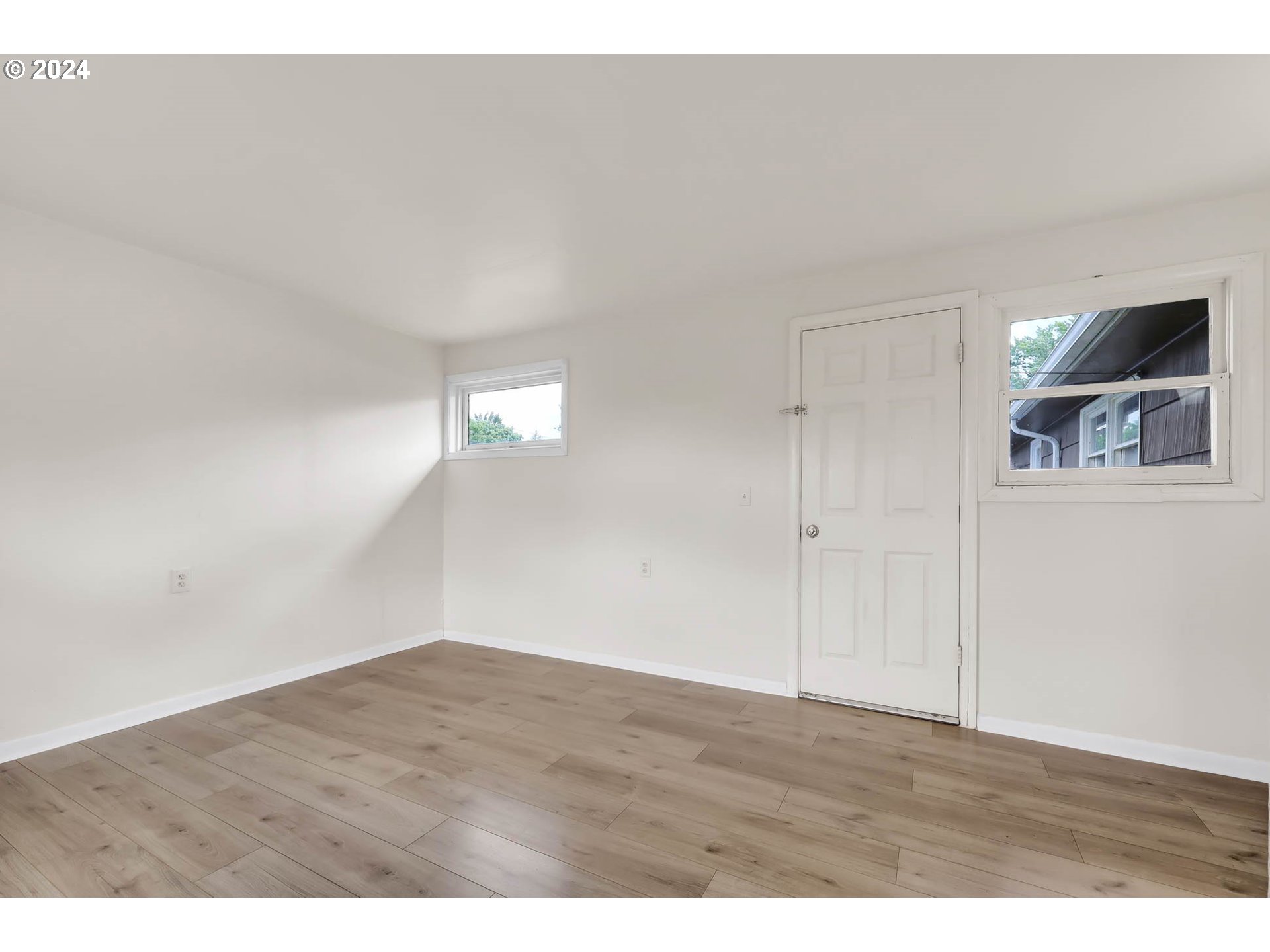 2915-2925 Oak Street Eugene, OR 97405 - Photo 13 of 42 a view of an empty room with wooden floor and window