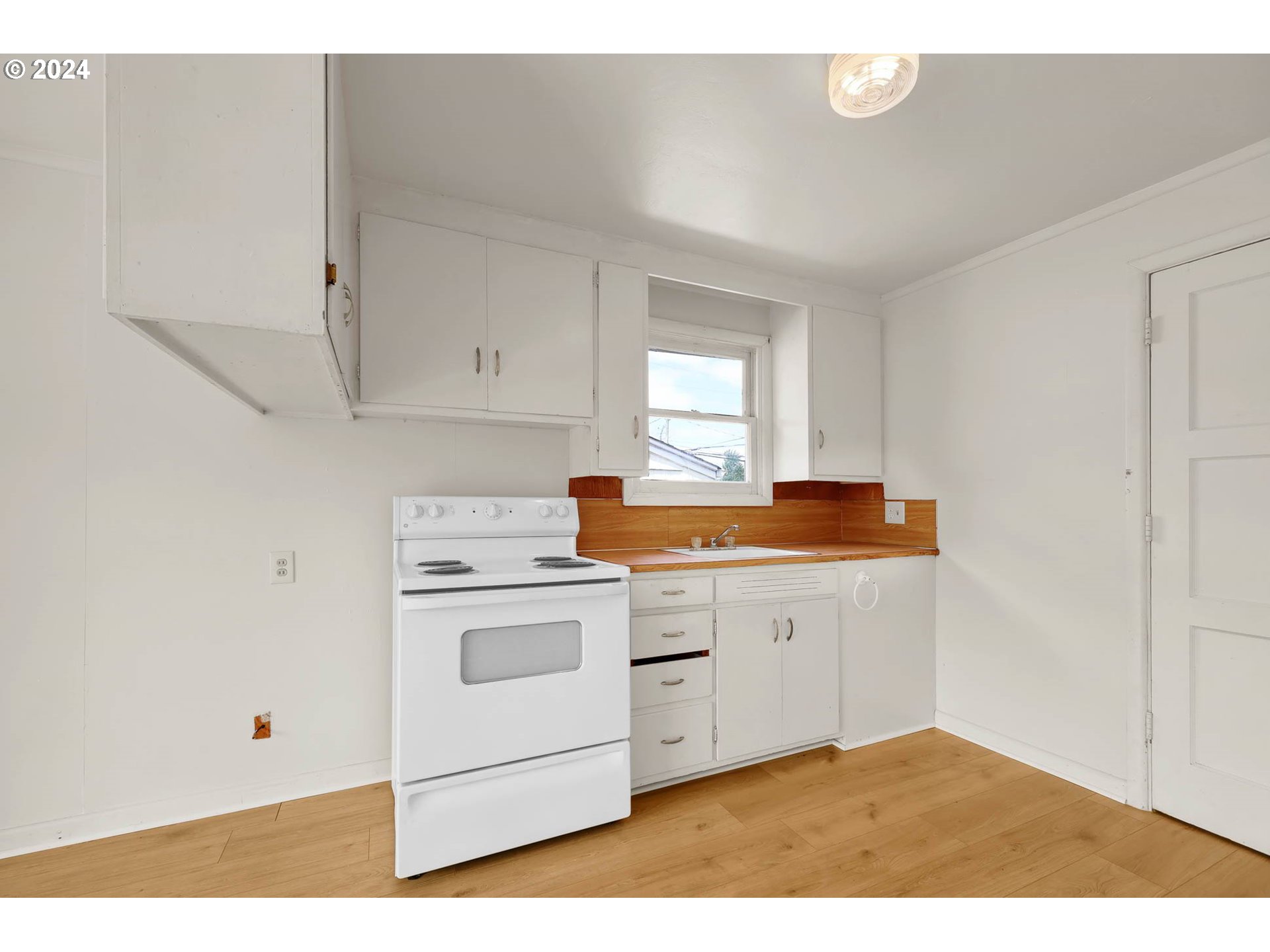 2915-2925 Oak Street Eugene, OR 97405 - Photo 16 of 42 a kitchen with a stove and white cabinets