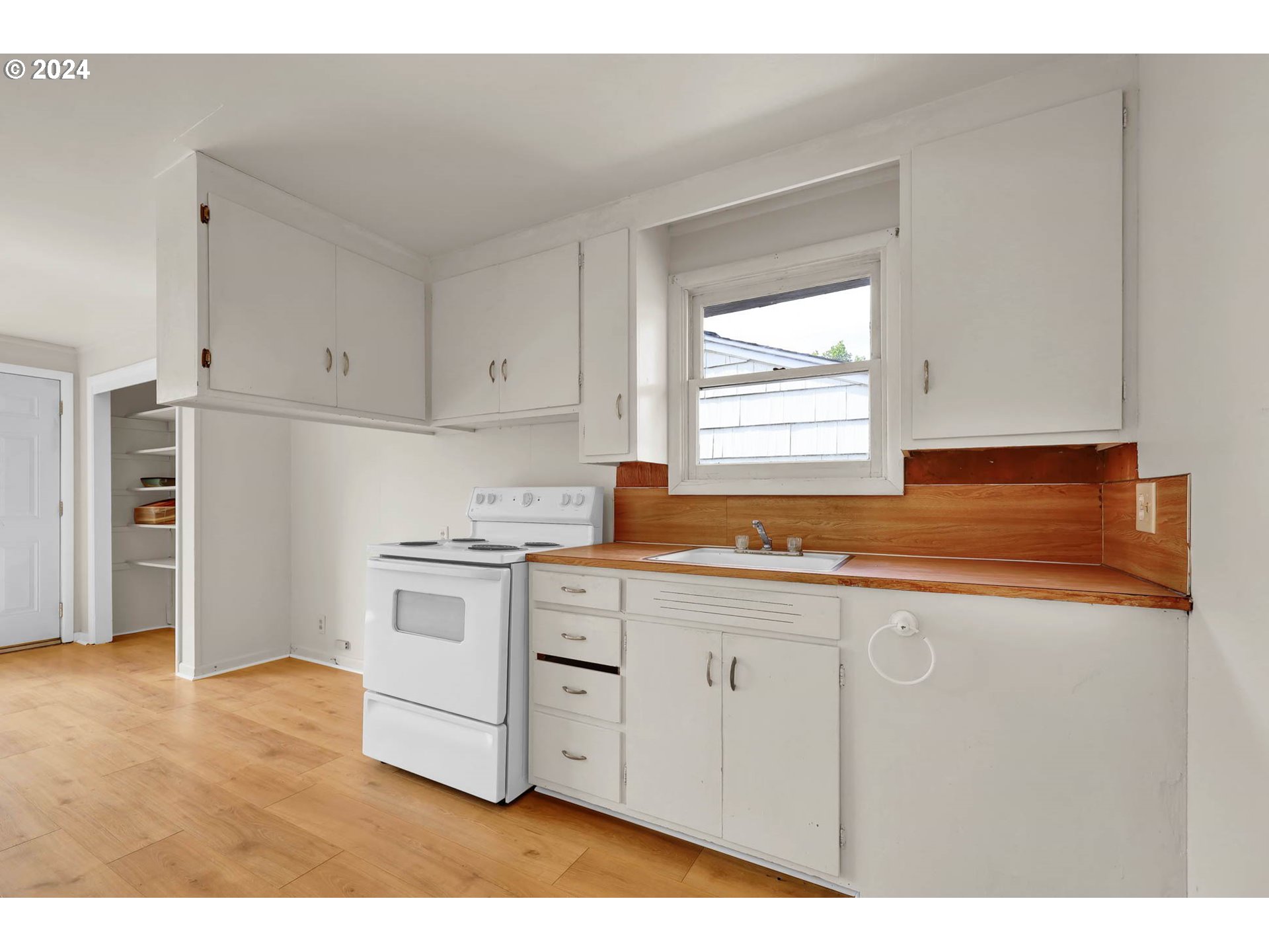2915-2925 Oak Street Eugene, OR 97405 - Photo 7 of 42 a kitchen with stainless steel appliances granite countertop a stove a sink and white cabinets with wooden floor