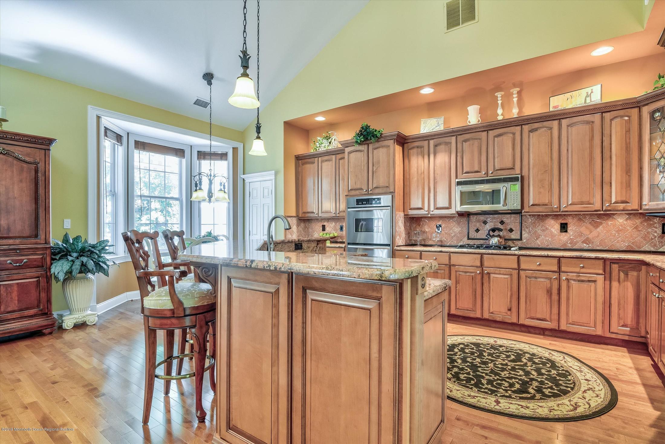 47 Portchester Drive Jackson, NJ 08527 - Photo 13 of 46 a kitchen with stainless steel appliances granite countertop a stove top oven a sink dishwasher and cabinets with wooden floor