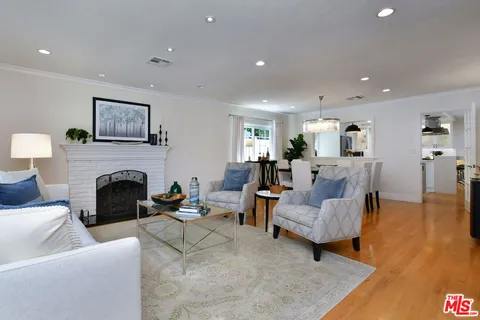 a living room with furniture fireplace and a large window
