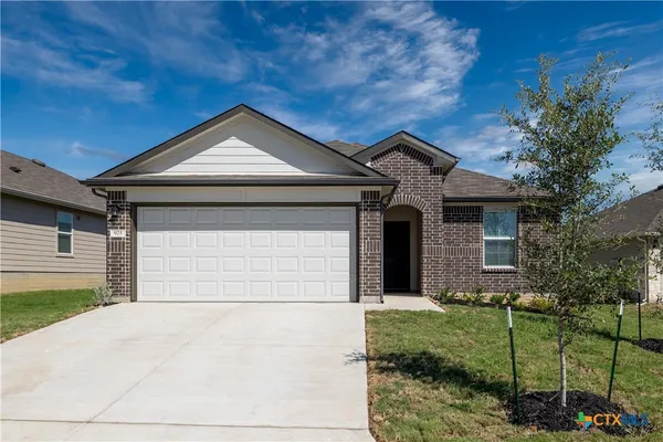 a front view of a house with a garden and garage