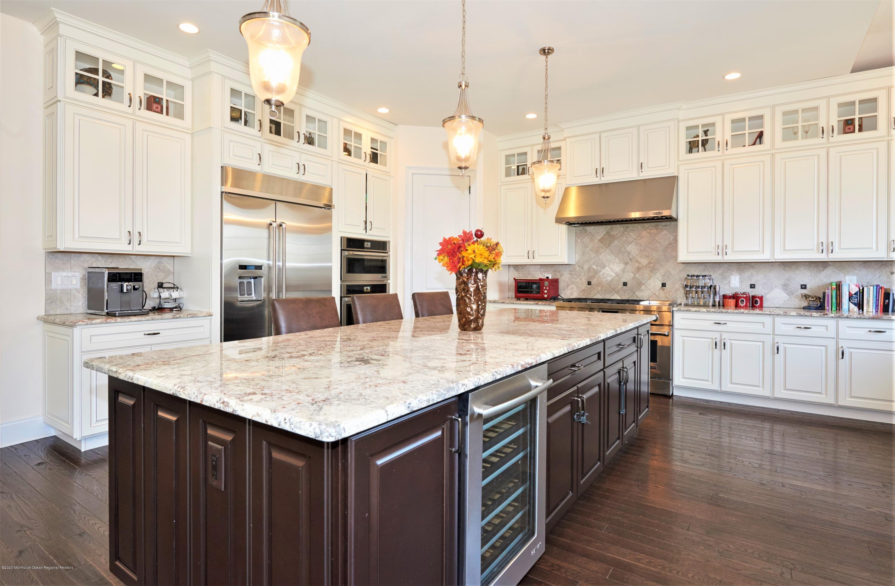 15 Windermere Road Lincroft, NJ 07738 - Photo 12 of 56 a kitchen with kitchen island granite countertop a white cabinets and refrigerator